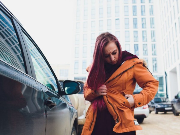 Pretty,Young,Woman,Standing,And,Looking,Keys,Of,Car,In